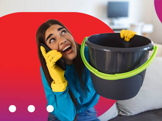 Smiling woman holding a bucket and on a phone call discussing a pre-approved loan.