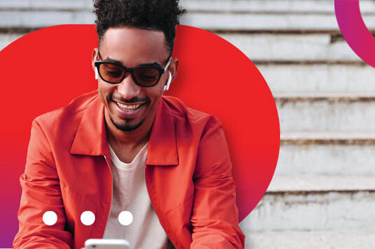 Man smiling at his phone after finding affordable personal loans with Atlas Finance's help.
